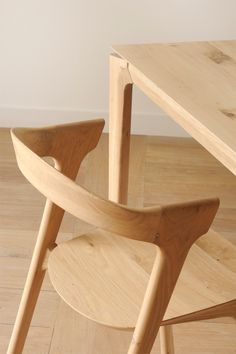 a wooden chair sitting on top of a hard wood floor next to a table and chairs