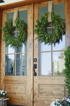 two wreaths are hanging on the front door