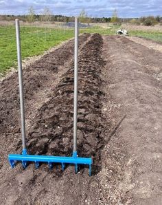 there are two poles that have been dug into the ground with blue plow attachments