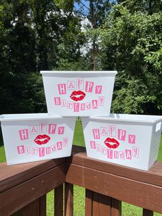 three coolers with happy birthday designs on them are sitting on a deck in front of some trees