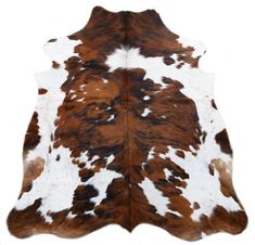 a brown and white cowhide rug on a white background