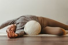 a woman is laying on the floor with her head down and arms behind her back