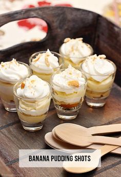 small desserts are arranged on a wooden tray