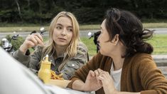 two women sitting at a table eating food