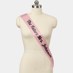 a mannequin with a pink sash on it