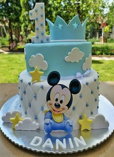 a blue and white cake with a mickey mouse on it's face, surrounded by stars