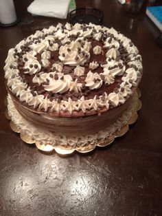 a chocolate cake with white frosting and skulls on it sitting on a table top