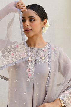 Grey kurta with intricate resham embroidery, applique florals highlighted with sequins and pearls in organza 3D rosettes, dori dots all over, with a delicate rosette lace running along the slit and hemline along the sleeves. Paired with embroidered farshi pant and embroidered sheer dupatta.
Components: 3
Pattern: Embroidered
Type Of Work: Resham
Neckline: Round
Sleeve Type: Cutwork
Fabric: Banaras Silk Base
Color: Grey
Other Details: 
Sheer dupatta
Floral applique
Organza bordered farshi pant
Oc Kashmiri Dress, Kurta Ideas, Applique Kurta, Plain Suits, Grey Kurta, Sheer Dupatta, Eastern Dresses, Resham Embroidery, Embroidery Fashion Detail