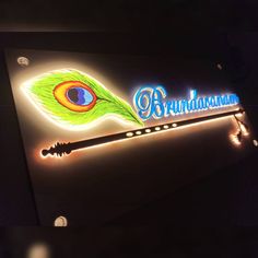 the sign is lit up with neon lights and a feather on it's tail