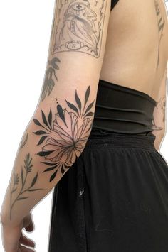 a woman's arm with tattoos on it and flowers in the middle of her arm