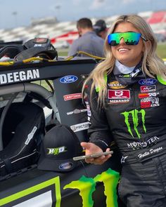 a woman in a racing outfit holding a cell phone