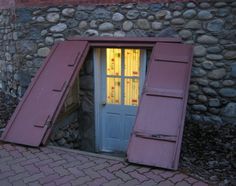 the door is open to let in light on the house's windows and shutters