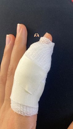 a woman's hand with bandages wrapped around her thumb