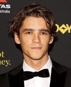 a young man in a tuxedo and bow tie at an awards gala event