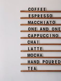 the wall is made up of different types of letters and numbers that spell out coffee, espresso, macchiato, one and cappuccino