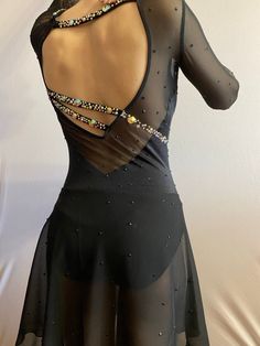 the back of a woman's black dress with beading