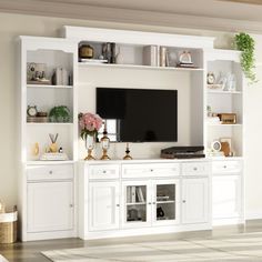 a living room with white furniture and a flat screen tv mounted on a wall unit