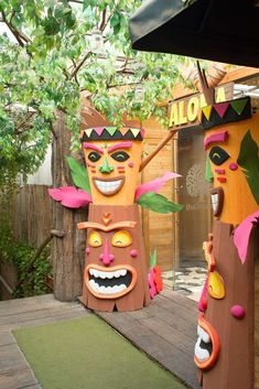 an outdoor area with two wooden carved faces and one has a tree in the background