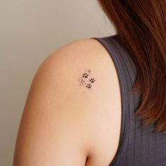 the back of a woman's shoulder with an animal paw tattoo on it