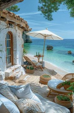 an outdoor area with chairs and umbrellas on the sand near the water's edge