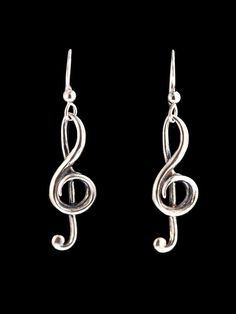 silver treble earrings on a black background