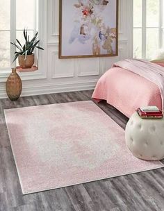 a bedroom scene with focus on the bed and pink carpeted area rug in the foreground