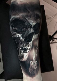 a man's arm with a skull tattoo on it