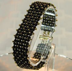 a black and gold beaded bracelet on display