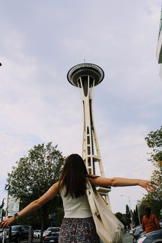 a woman is standing in front of the space needle