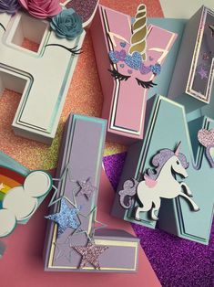 some unicorn themed items are laying out on the ground and one is pink, purple, blue and white