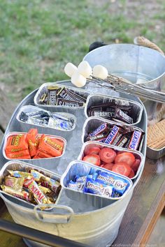 a metal container filled with food sitting on top of a table next to a picnic table