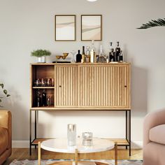 a living room filled with furniture next to a wall mounted art piece on top of a wooden cabinet