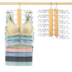 three bras hanging on a clothes rack next to two wooden hangers with metal clips