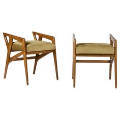 two wooden chairs with beige upholstered seats and arms, one in the shape of a cross