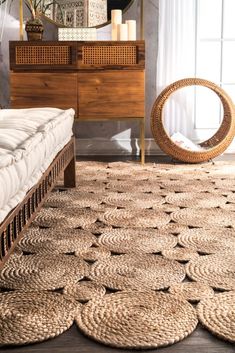 an area rug with circles on it in front of a dresser and mirror that is next to a bed