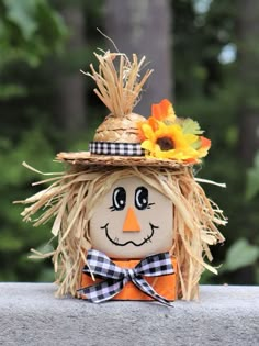 a scarecrow made out of hay with sunflowers on it's head