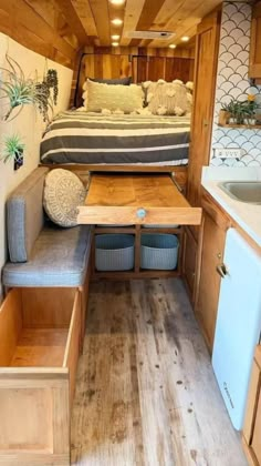 the interior of a travel trailer with a bed, sink and kitchenette in it