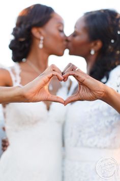 two brides making a heart with their hands