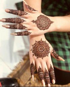 two hands with henna tattoos on them