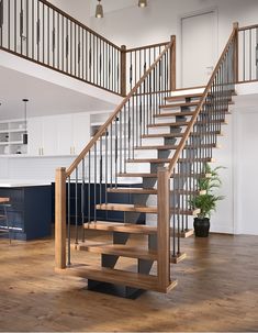 a wooden stair case with metal handrails in a kitchen and living room area