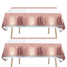 two tables covered in pink and white tablecloths with trees on the top,