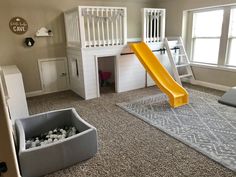 a child's play room with a slide and ball pit