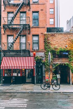 a bike parked in front of a building on a city street with ivy growing up the side of it