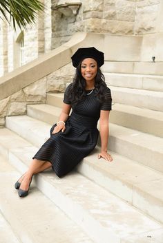 a woman is sitting on some steps wearing a black hat and dress with her legs crossed