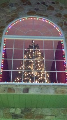 a christmas tree is seen through a window