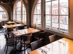 an empty restaurant with tables and chairs in front of large windows that look out onto the street