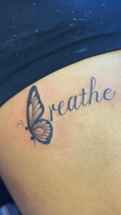 a woman's stomach with the words breathe and a butterfly tattoo on her side