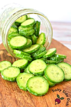 sliced cucumbers in a jar on a cutting board