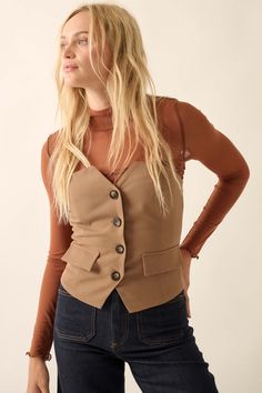 Bustier-style top with blazer styling. Strapless neckline. Button front closure. Decorative pocket flaps. Low, smocked elastic back. Fitted silhouette. 100% Polyester. Imported. Designed in LA. Model wears size S. Chic Tailored Tops With Buttons, Chic Button Closure Vest For Fall, Chic Beige Single Breasted Top, Chic Tailored Top With Button Closure, Chic Tailored Tops With Button Closure, Tailored Button Tops, Fitted Single Breasted Top For Workwear, Fitted Summer Blazer With Button Closure, Chic Single-breasted Top For Day Out