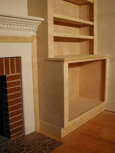 an empty room with a fireplace and shelves